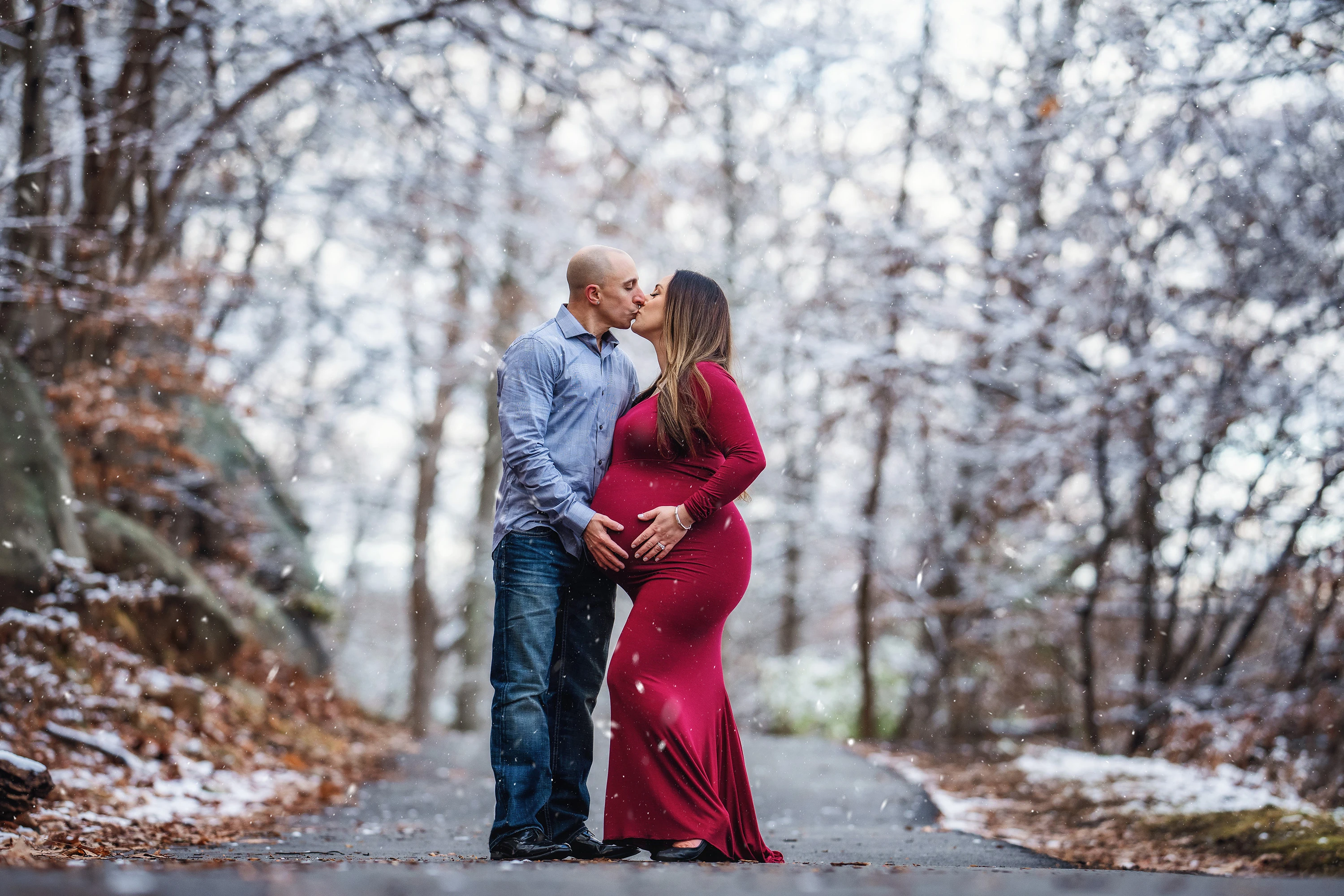 maternity photo of couple kissing outdoors