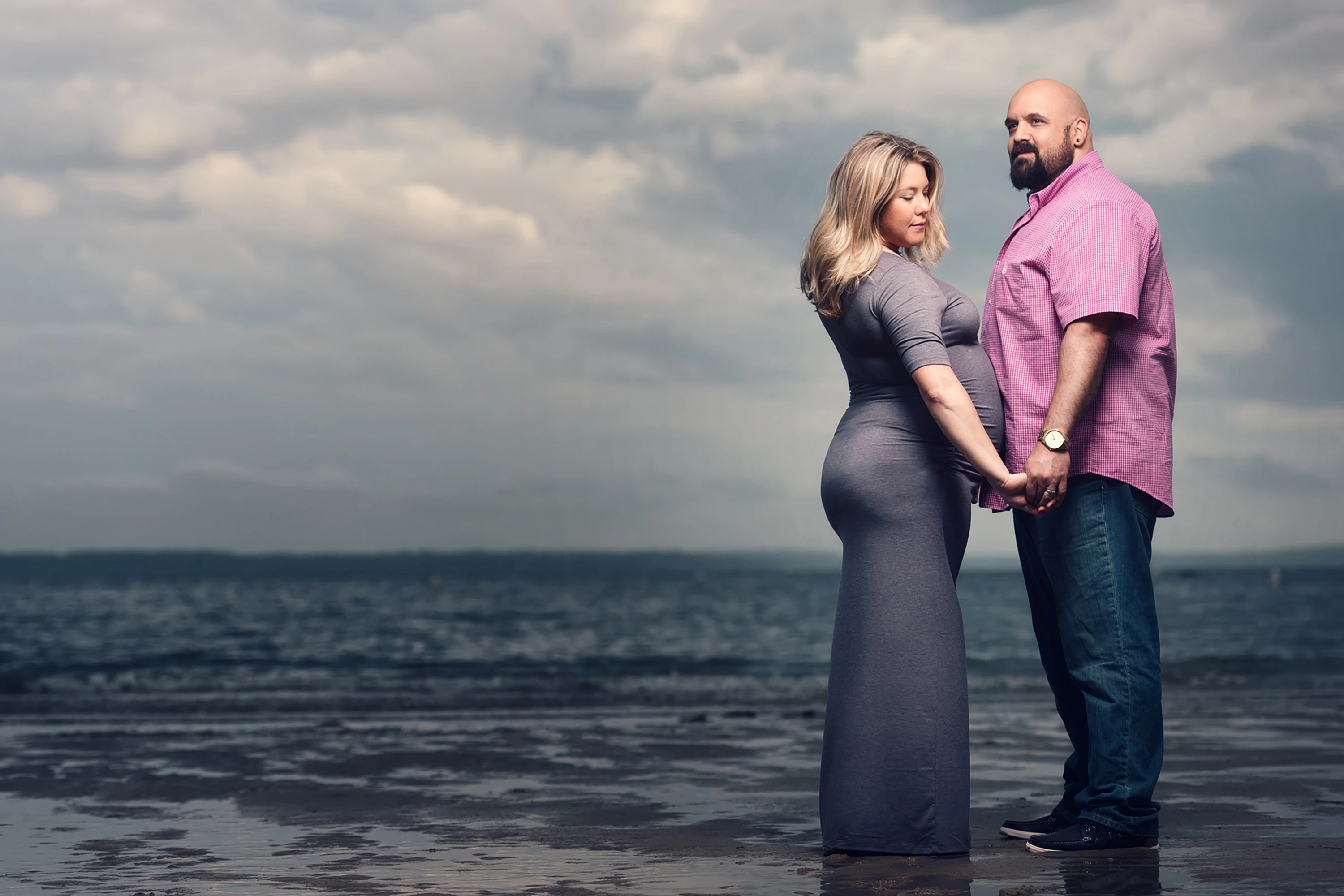 man and woman holding hands maternity photo
