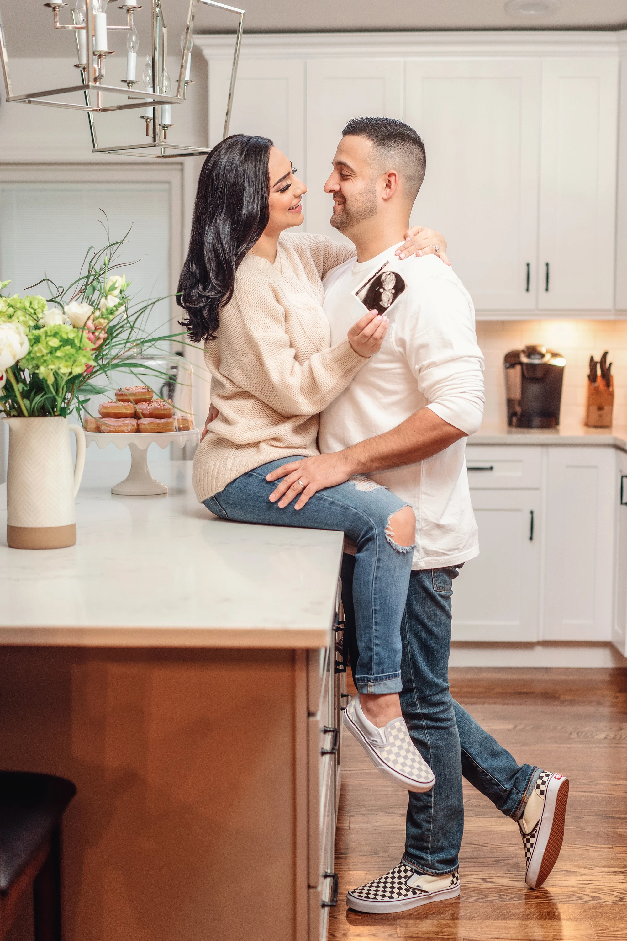 man hugging woman as woman holds sonogram