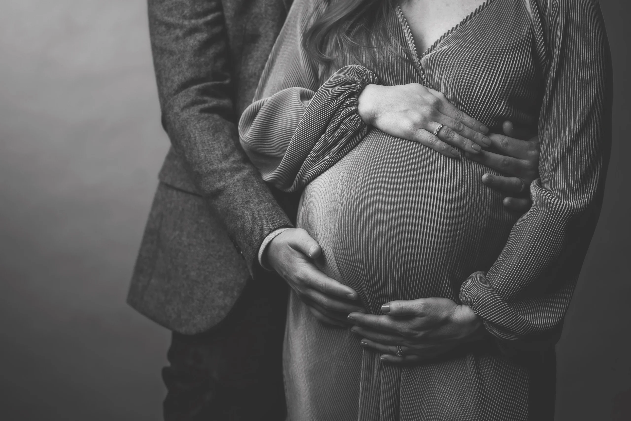 close up of man holding woman's stomach for maternity photoshoot