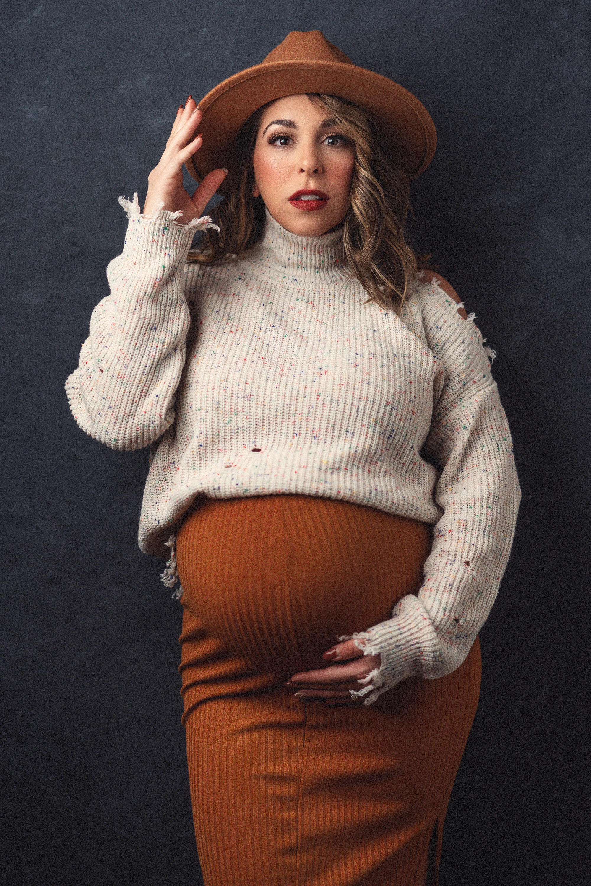 maternity photo of woman in skirt and sweater