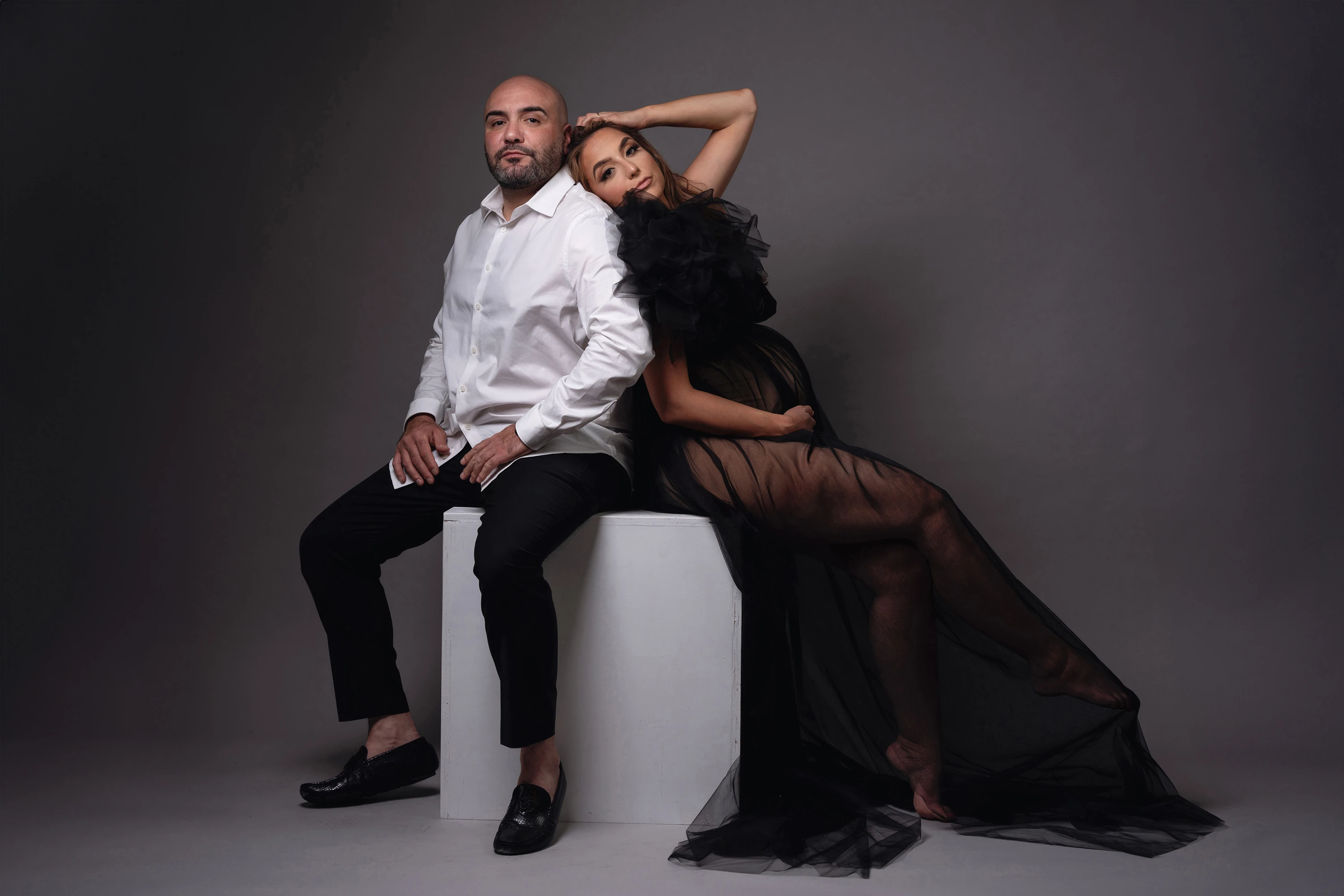 maternity photos of man and woman sitting back to back