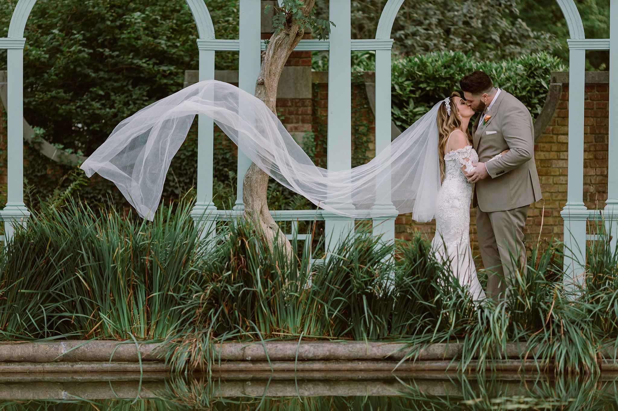 wedding photo of bride and groom kissing outside