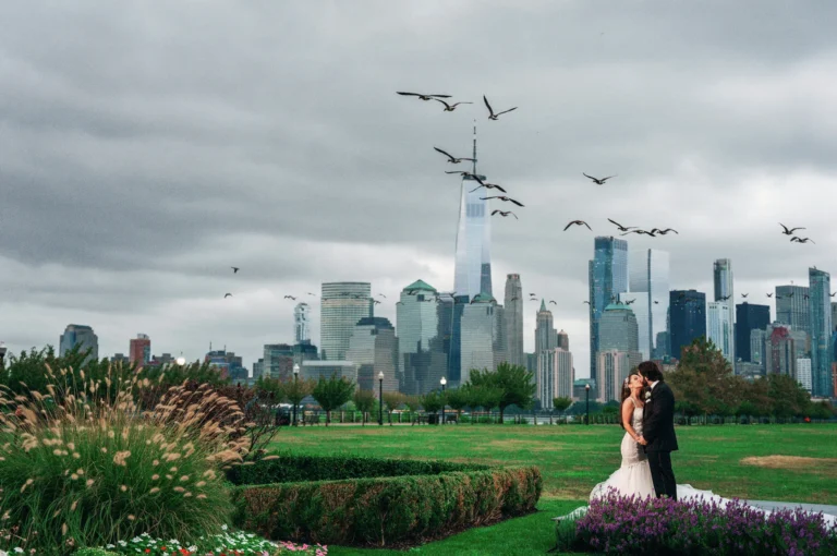 Photo of bride and groom kissing with city backdrop