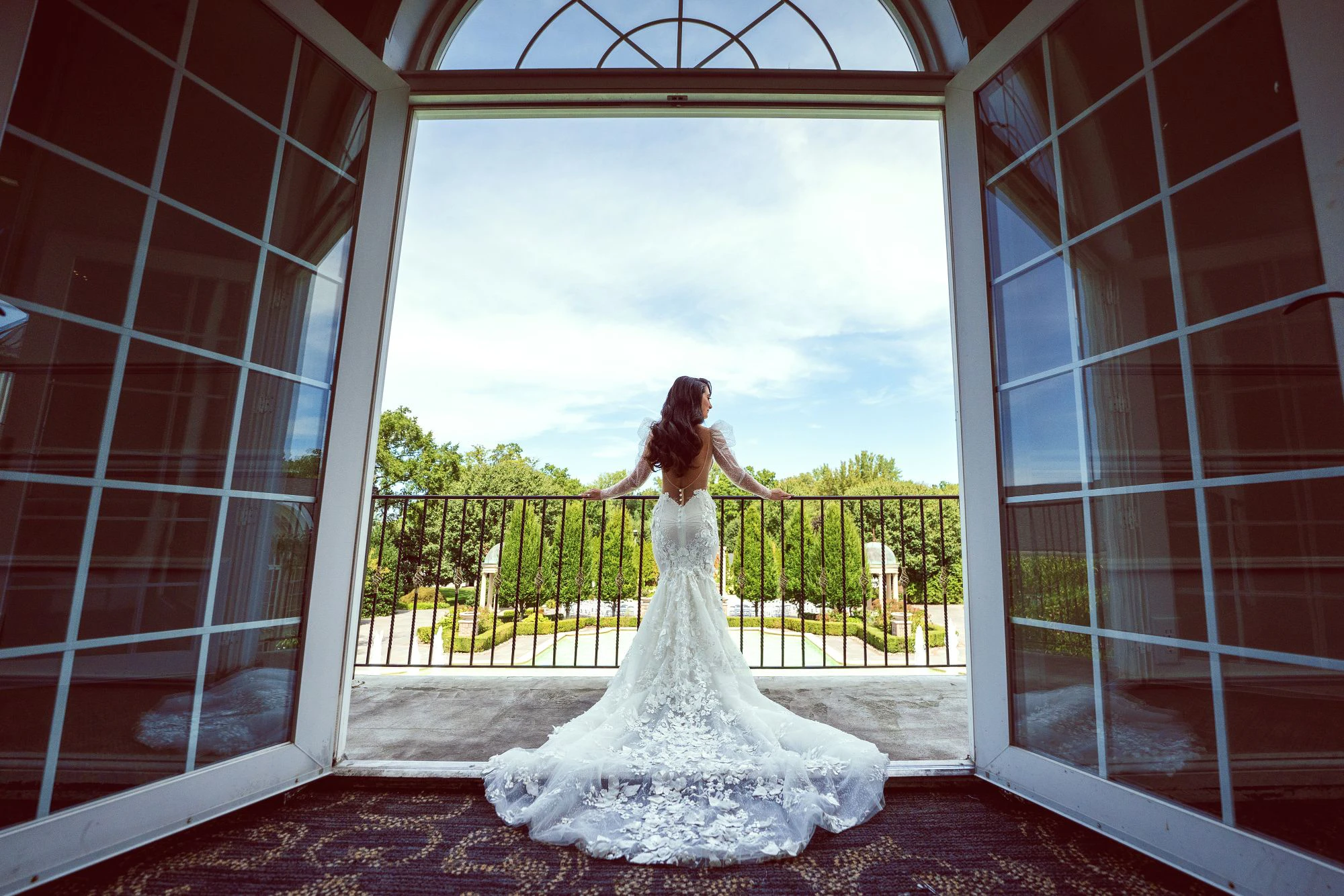 Wedding photography portrait of bride looking out over wedding venue from Juliet Balcony