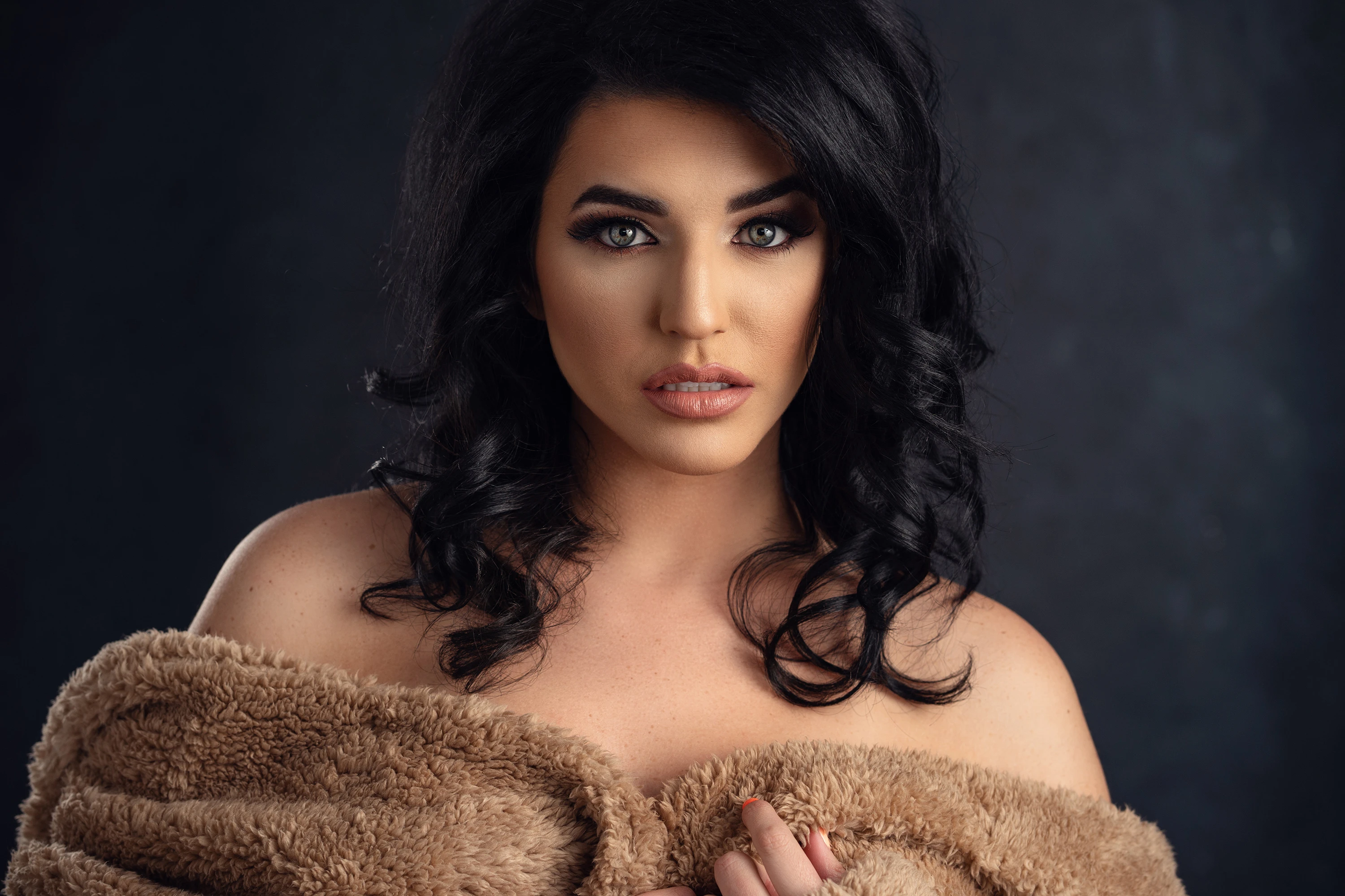 creative portrait of woman with black hair wrapped in a blanket