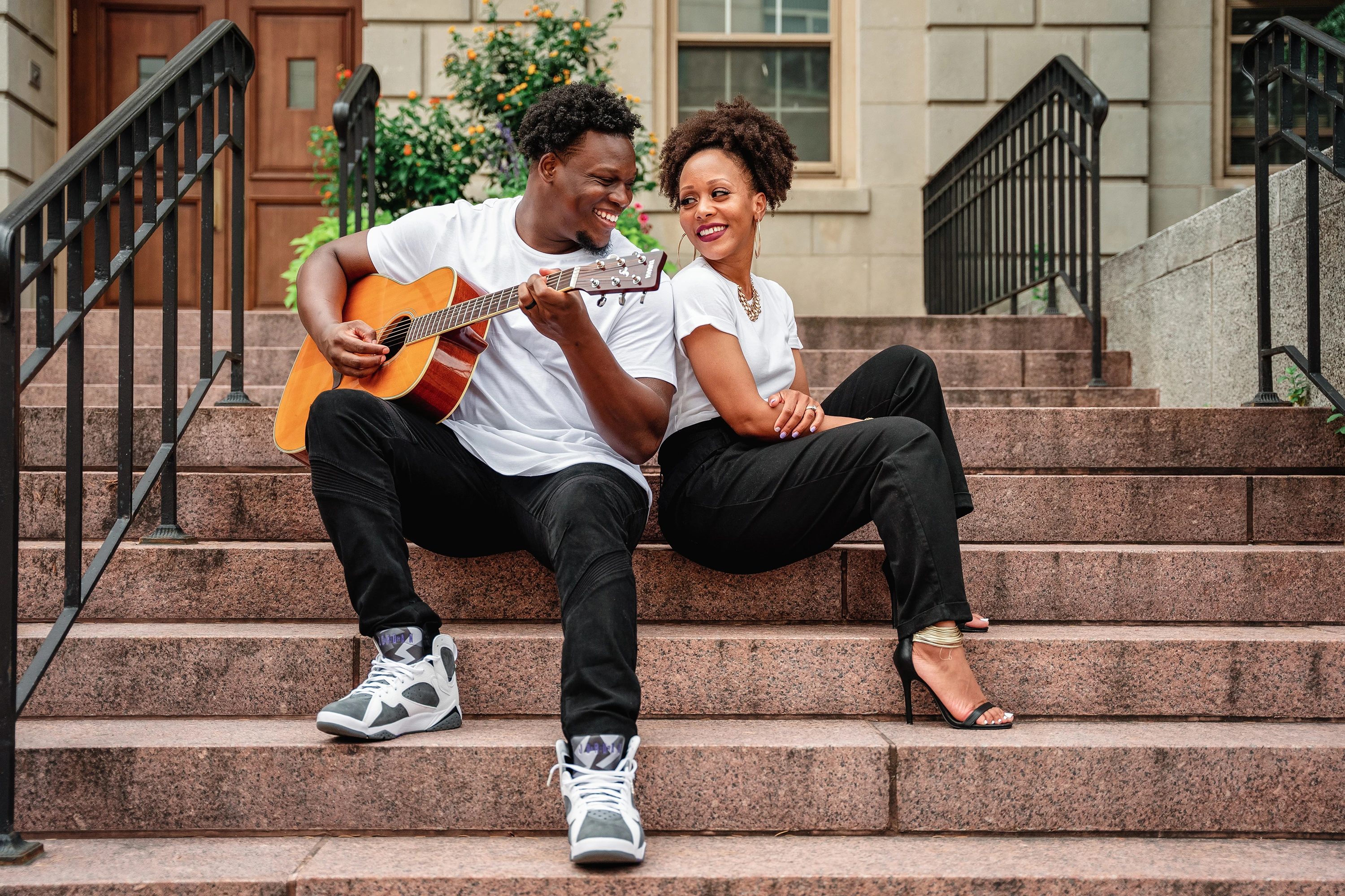 portrait of man and woman looking into each other's eye wearing black pants and white t shirts