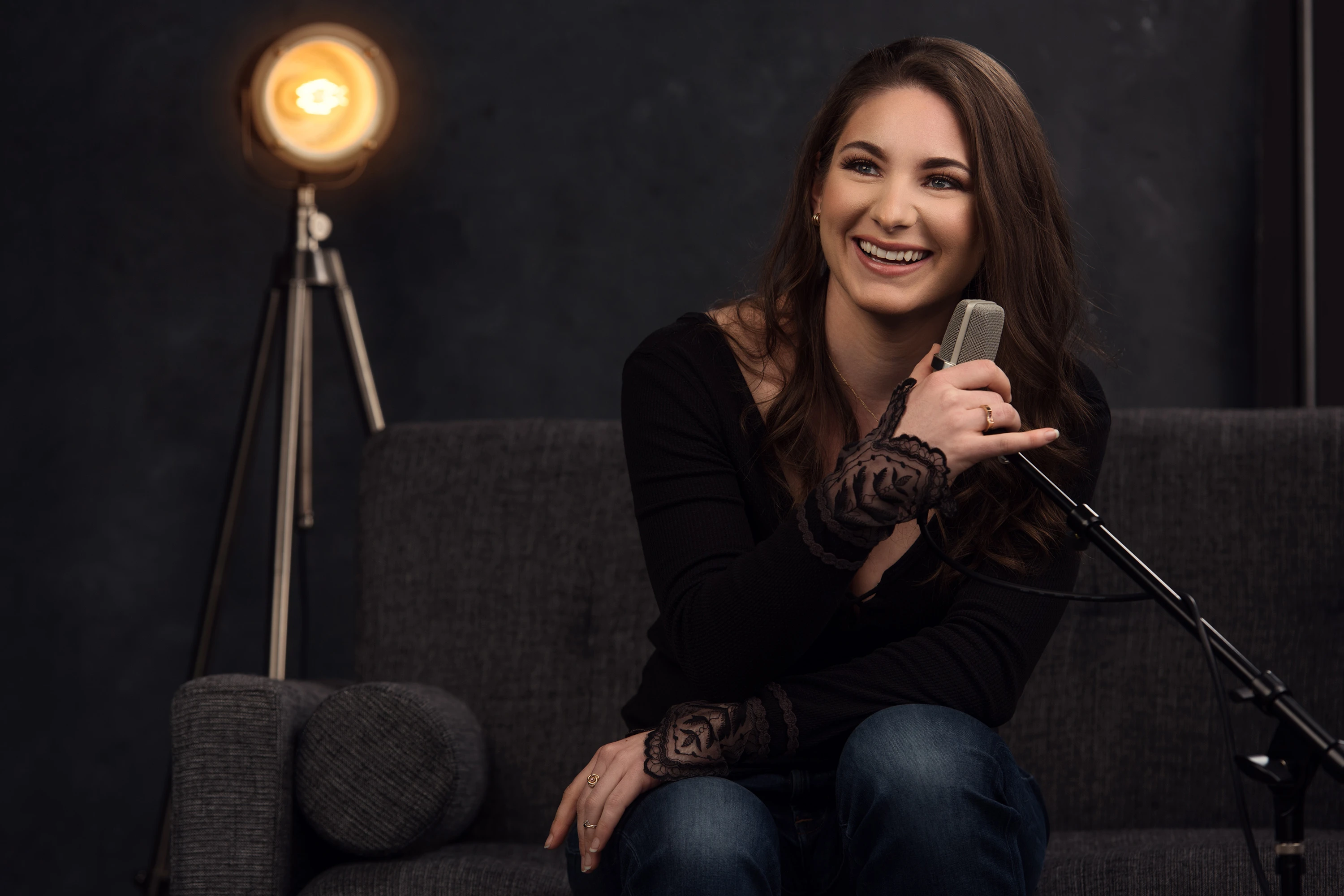 creative portrait of woman posing with her podcast microphone