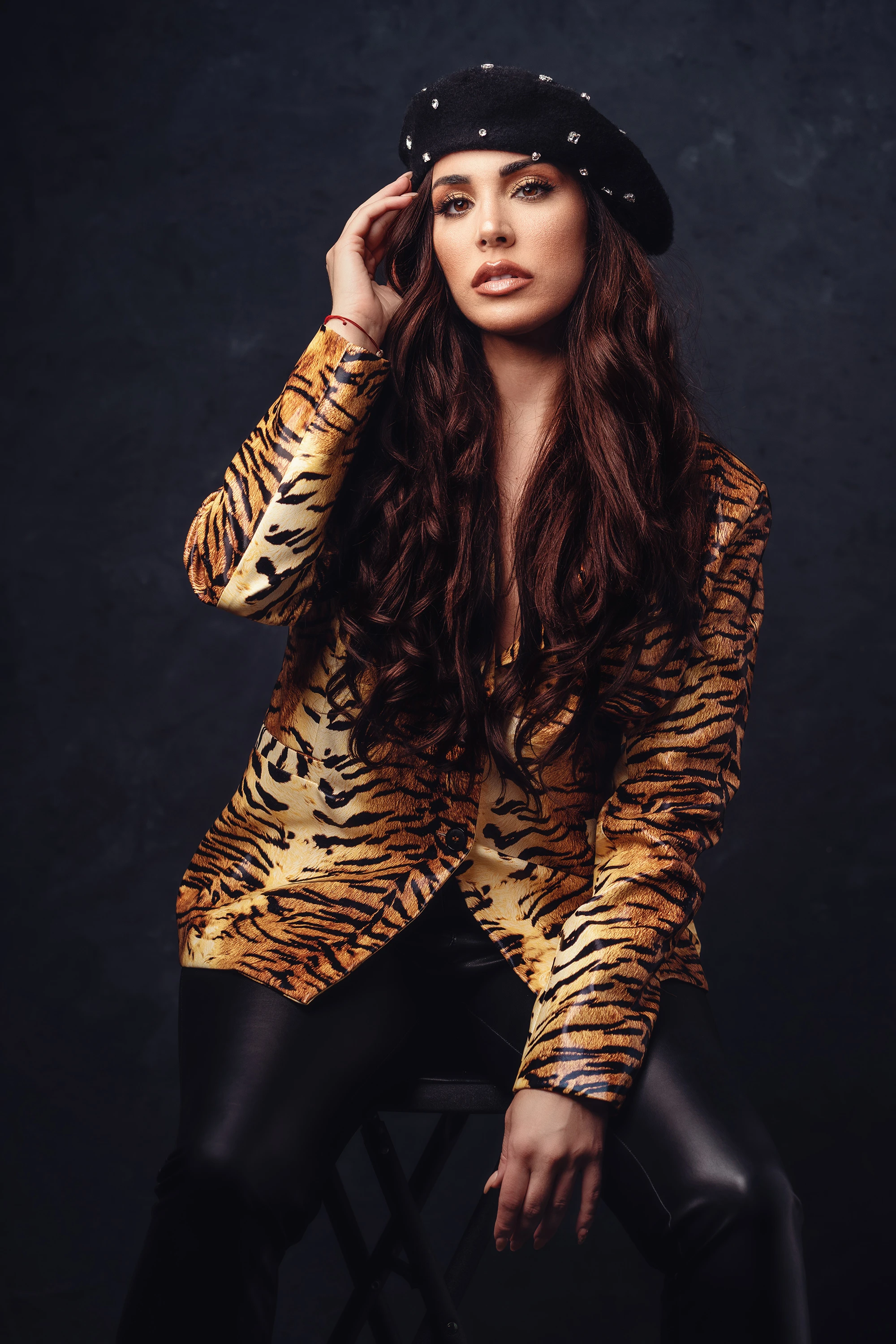 creative portrait of woman in tiger stripped jacket and hat