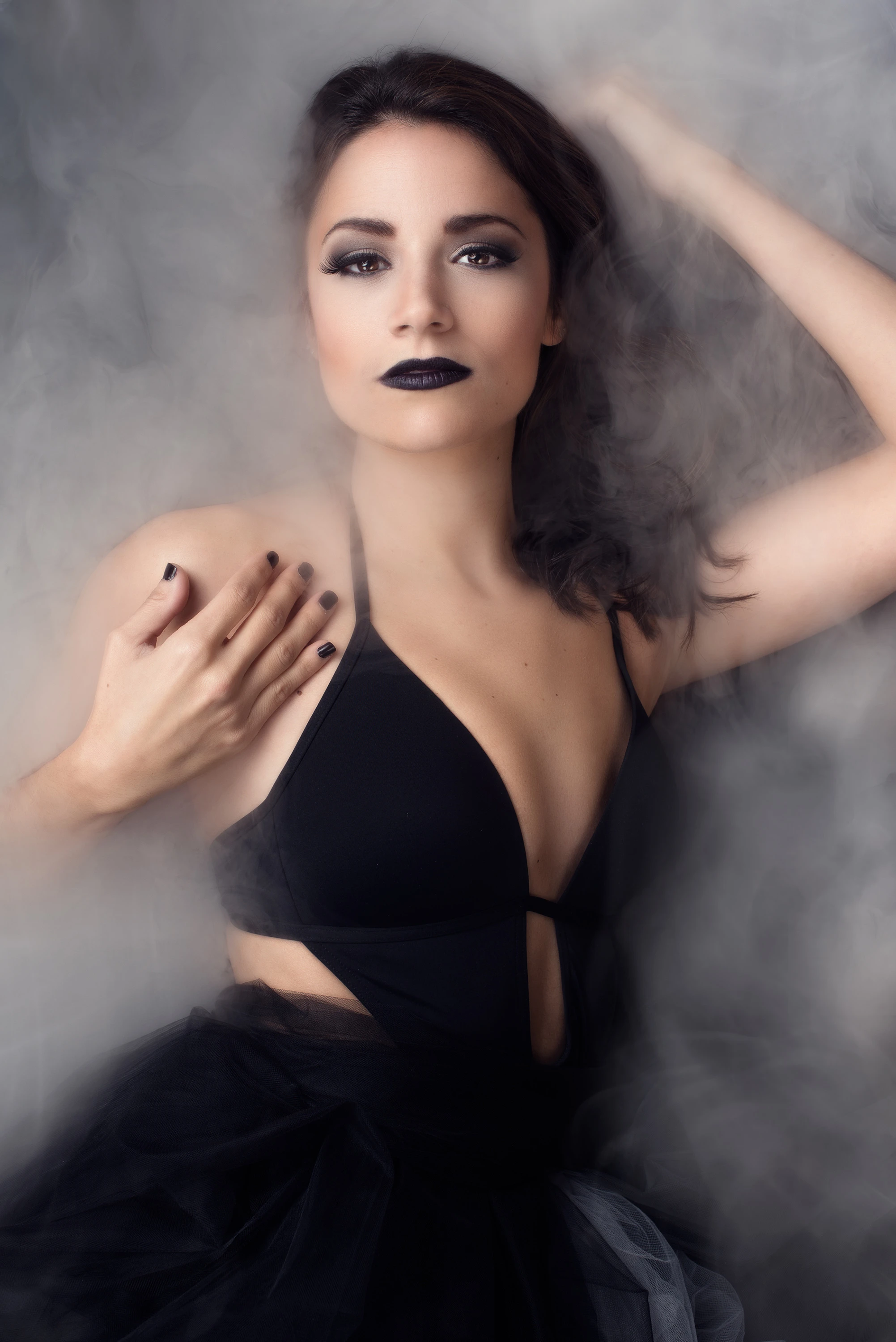 creative portrait of woman in black dress with smoke around her