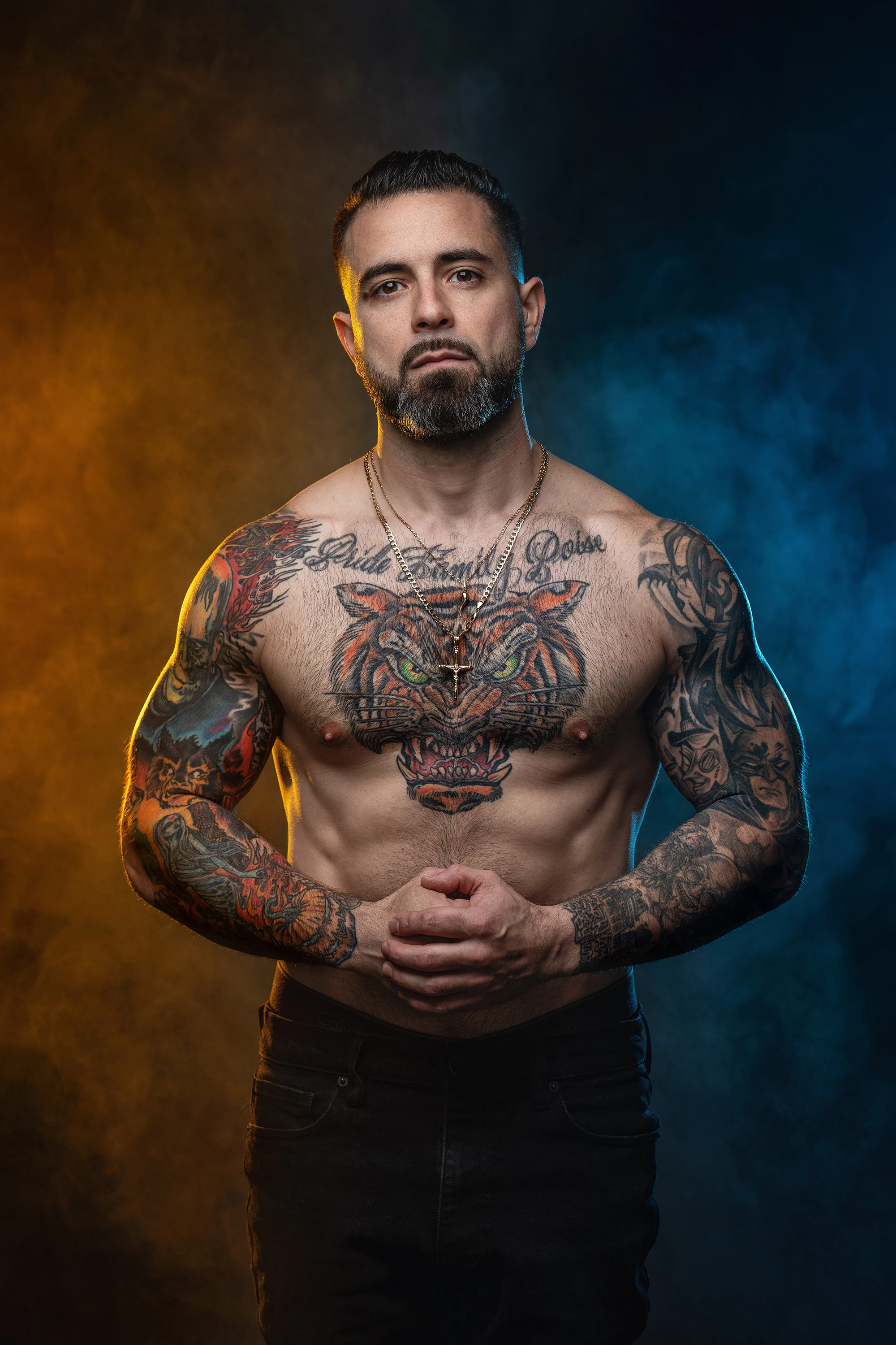 close up portrait of man with athletic build with no shirt on and colorful tattoos