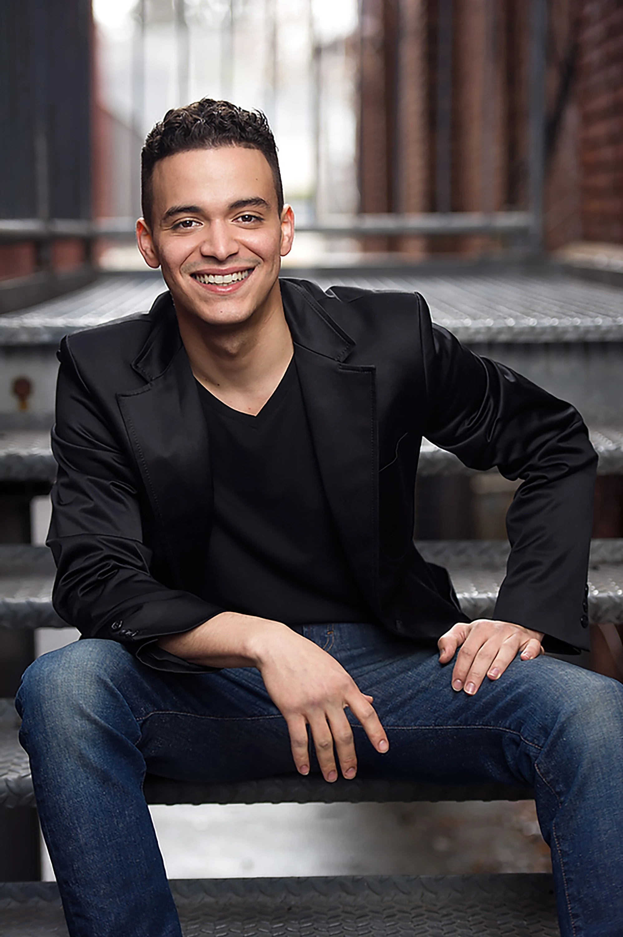 portrait of man sitting down in black blazer