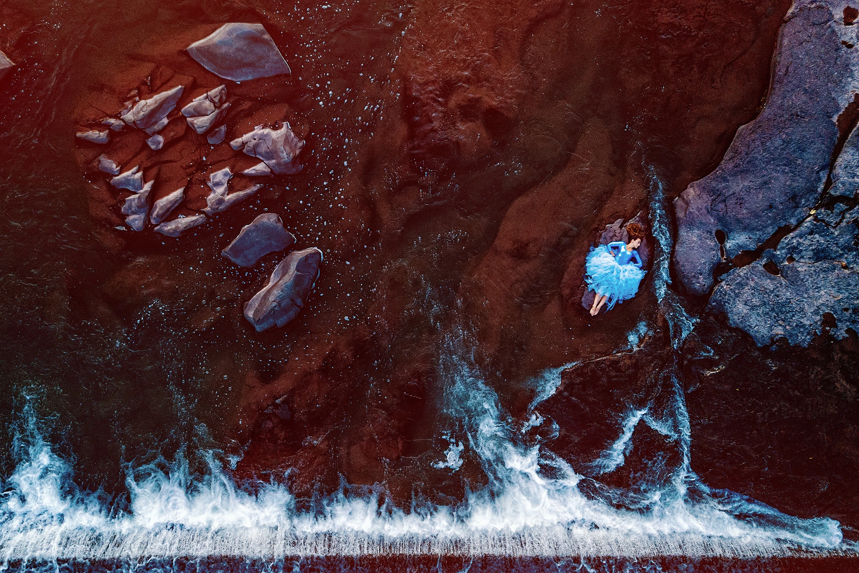 creative portrait of woman in blue dress posing by the water