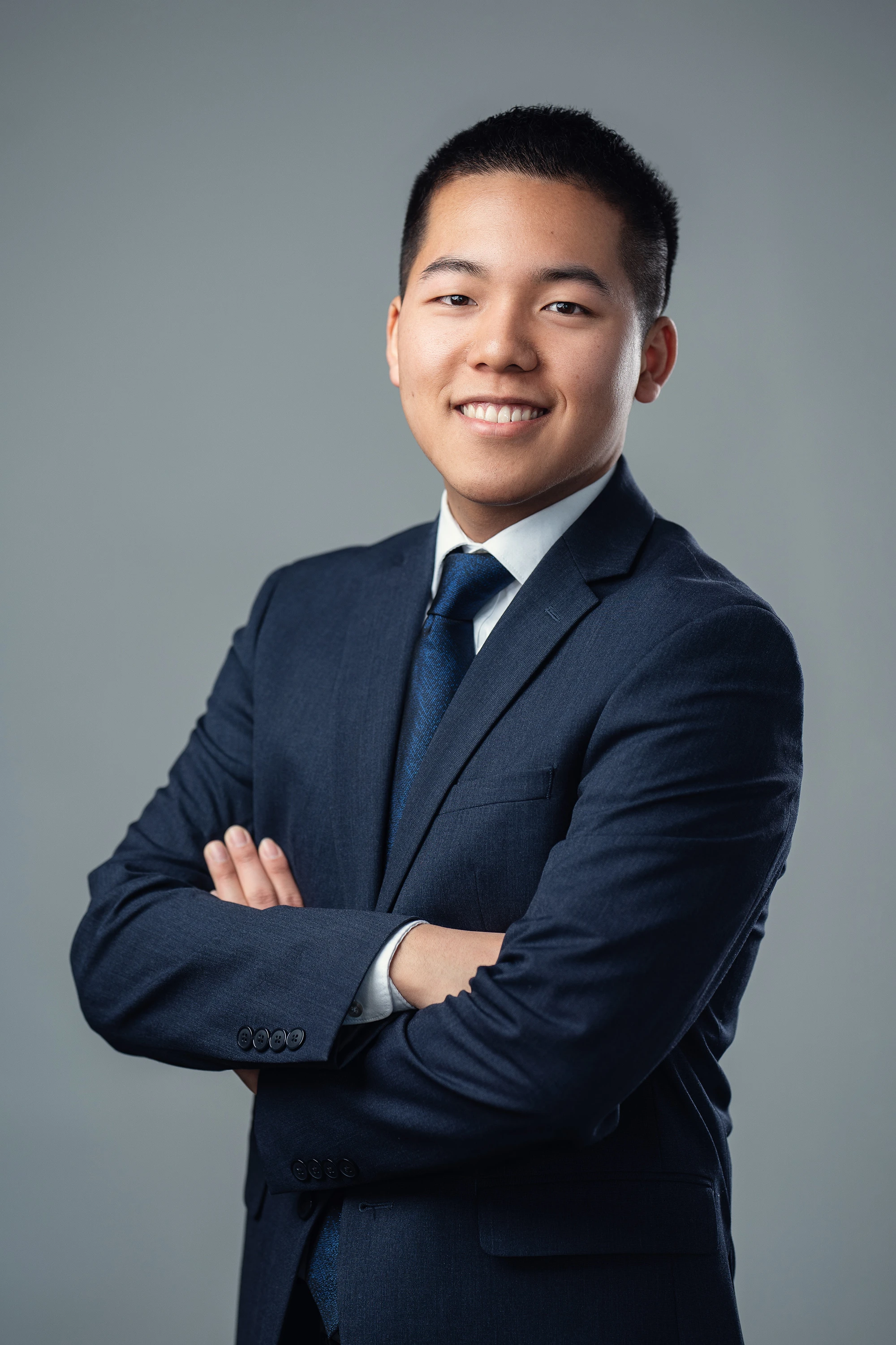 professional headshot of man in blue suit and blue tie