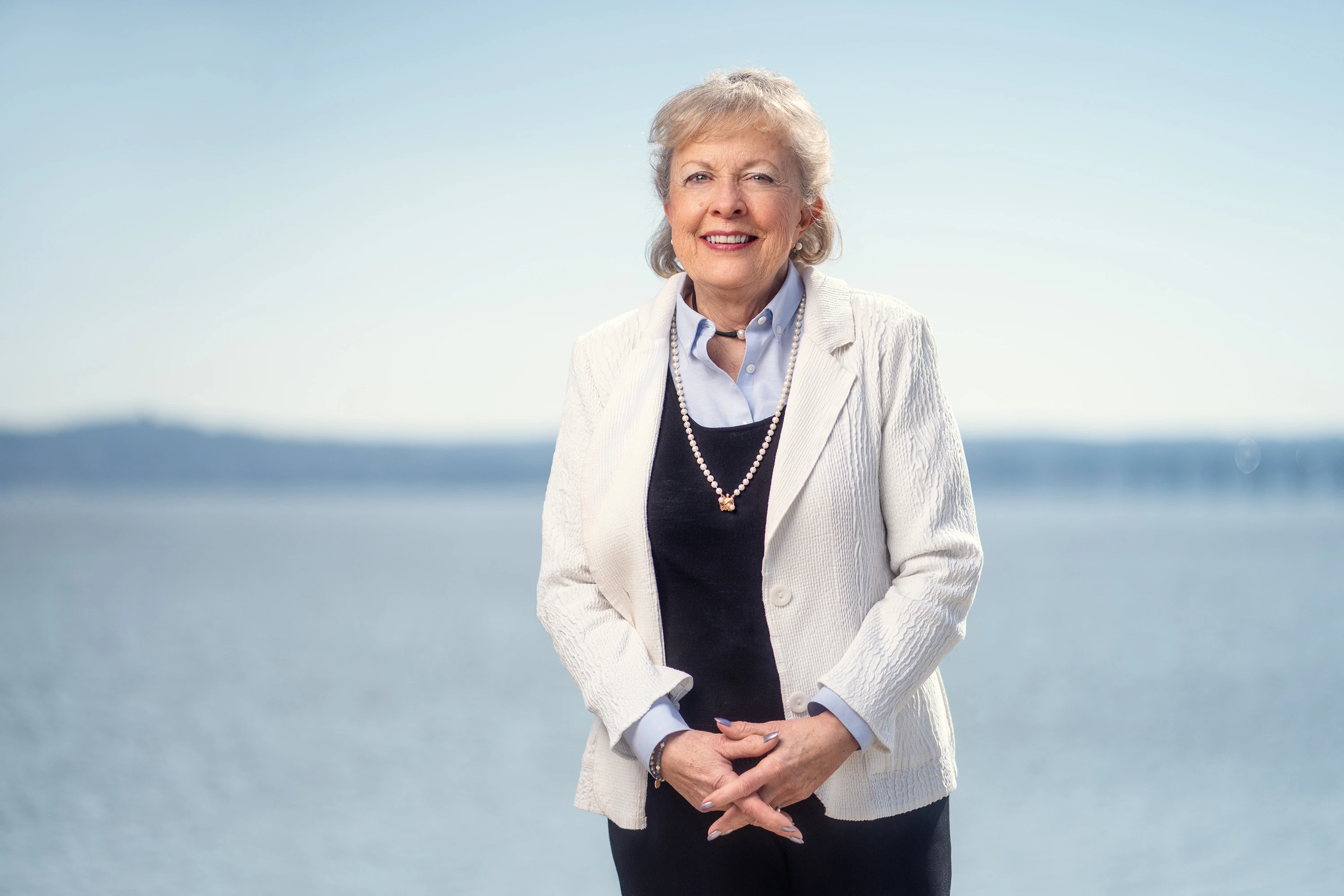 professional headshot of of woman wearing white blazer with blurred background