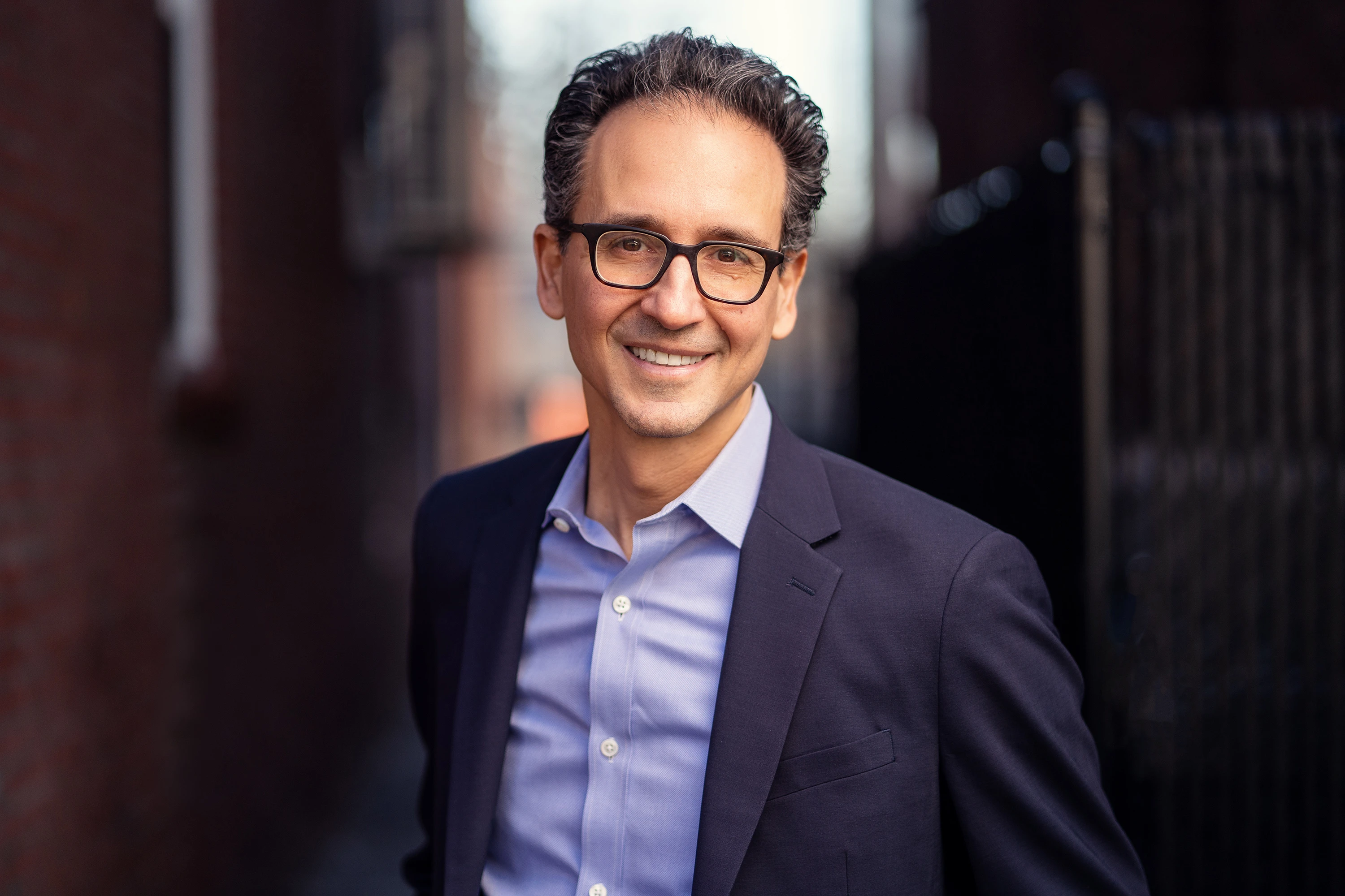 professional headshot of man in glasses and suit