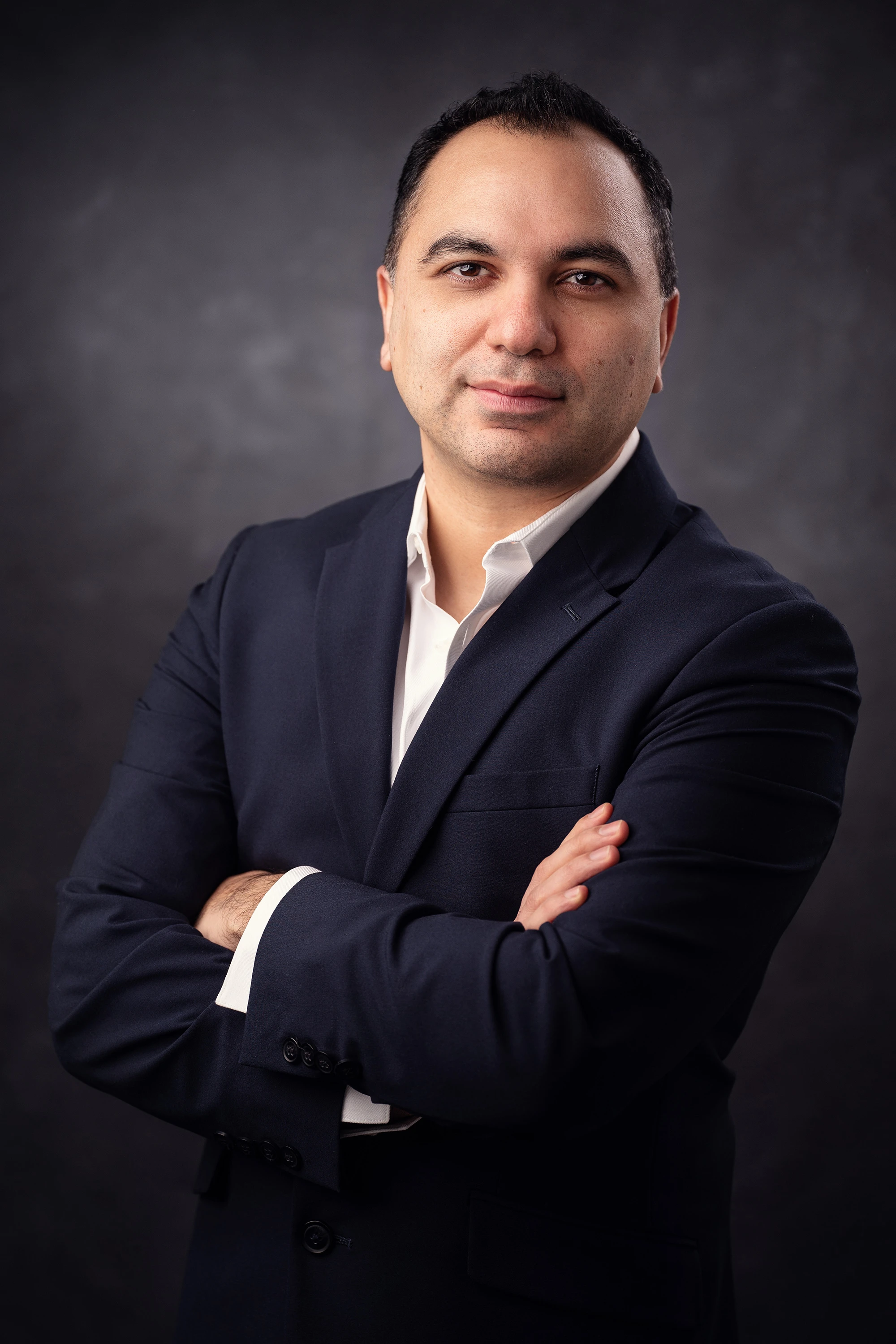 professional headshot of man in blue suit with white button down