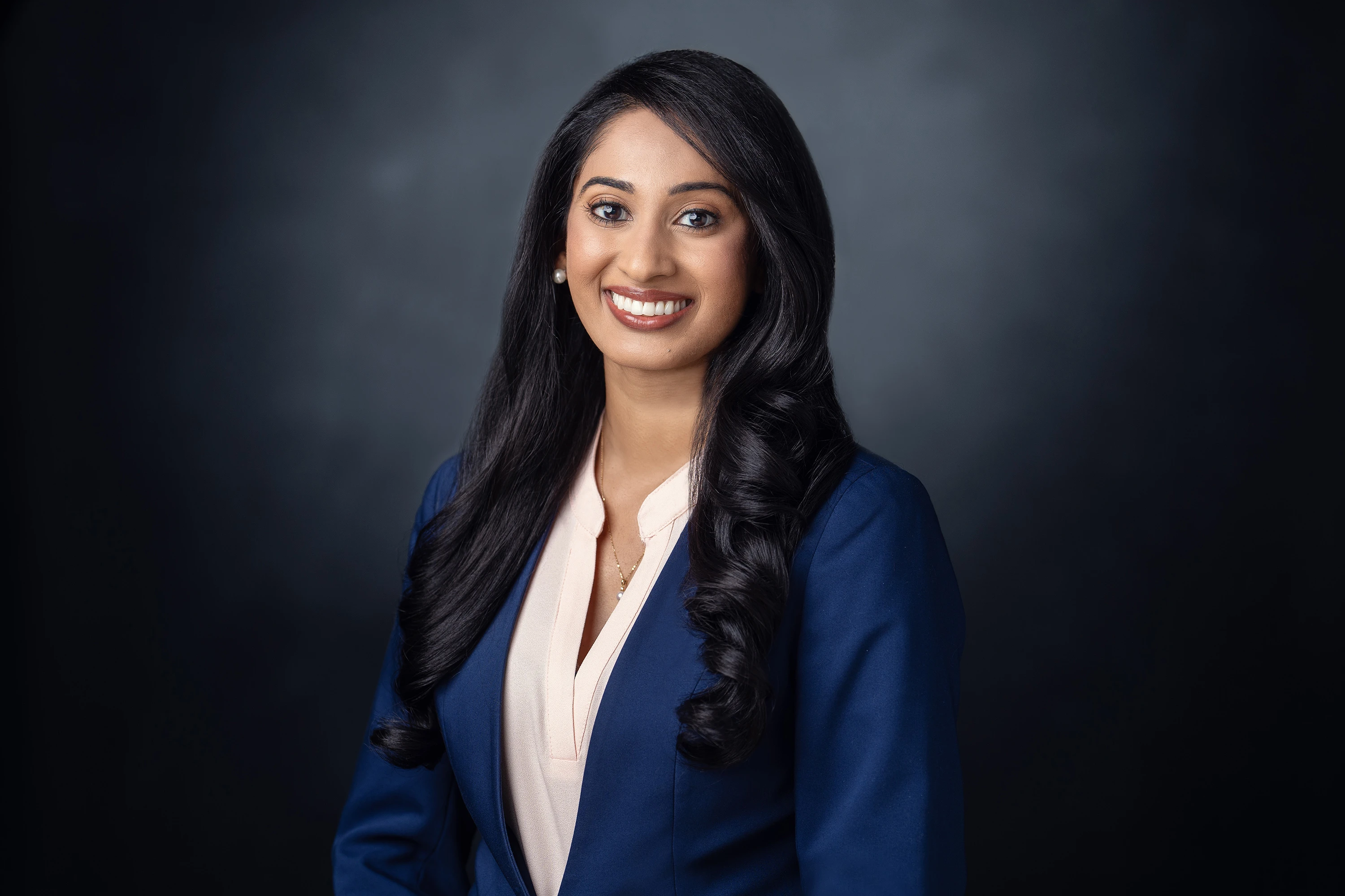 Woman posing in blue blazer and white button down shirt for headshot