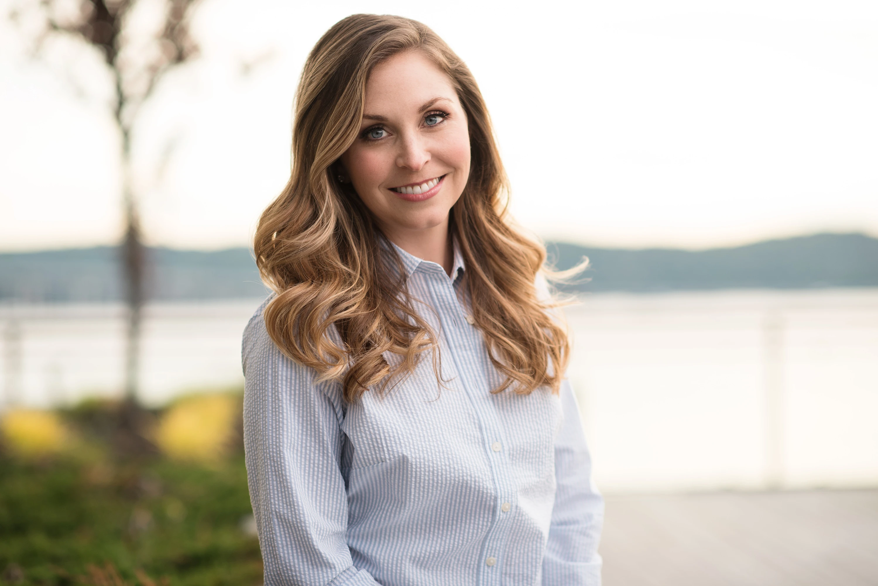 headshot of woman with light blonde hair posing outdoors for headshot